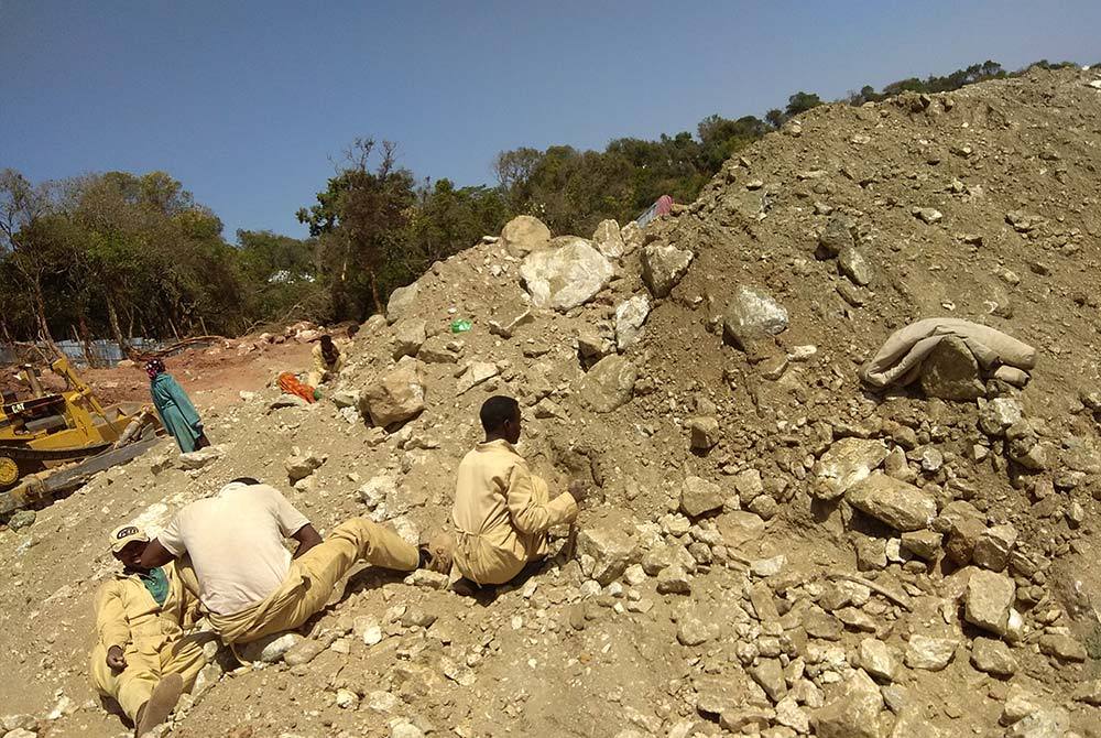 Sorting through waste pile at an emerald mine, Ethiopia.